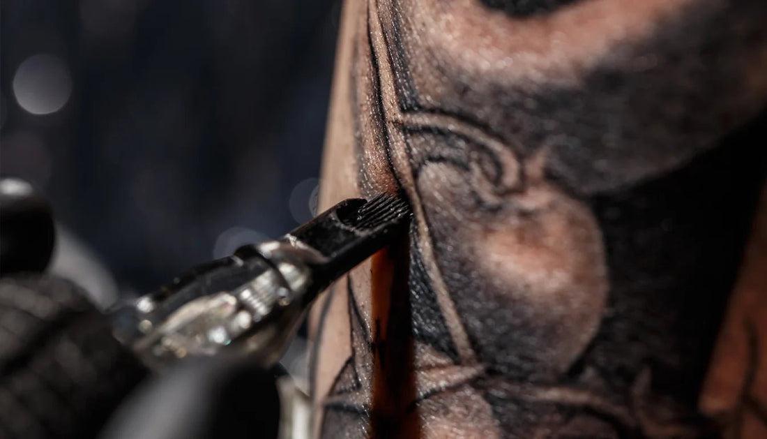 Close-up of a tattoo needle penetrating the skin